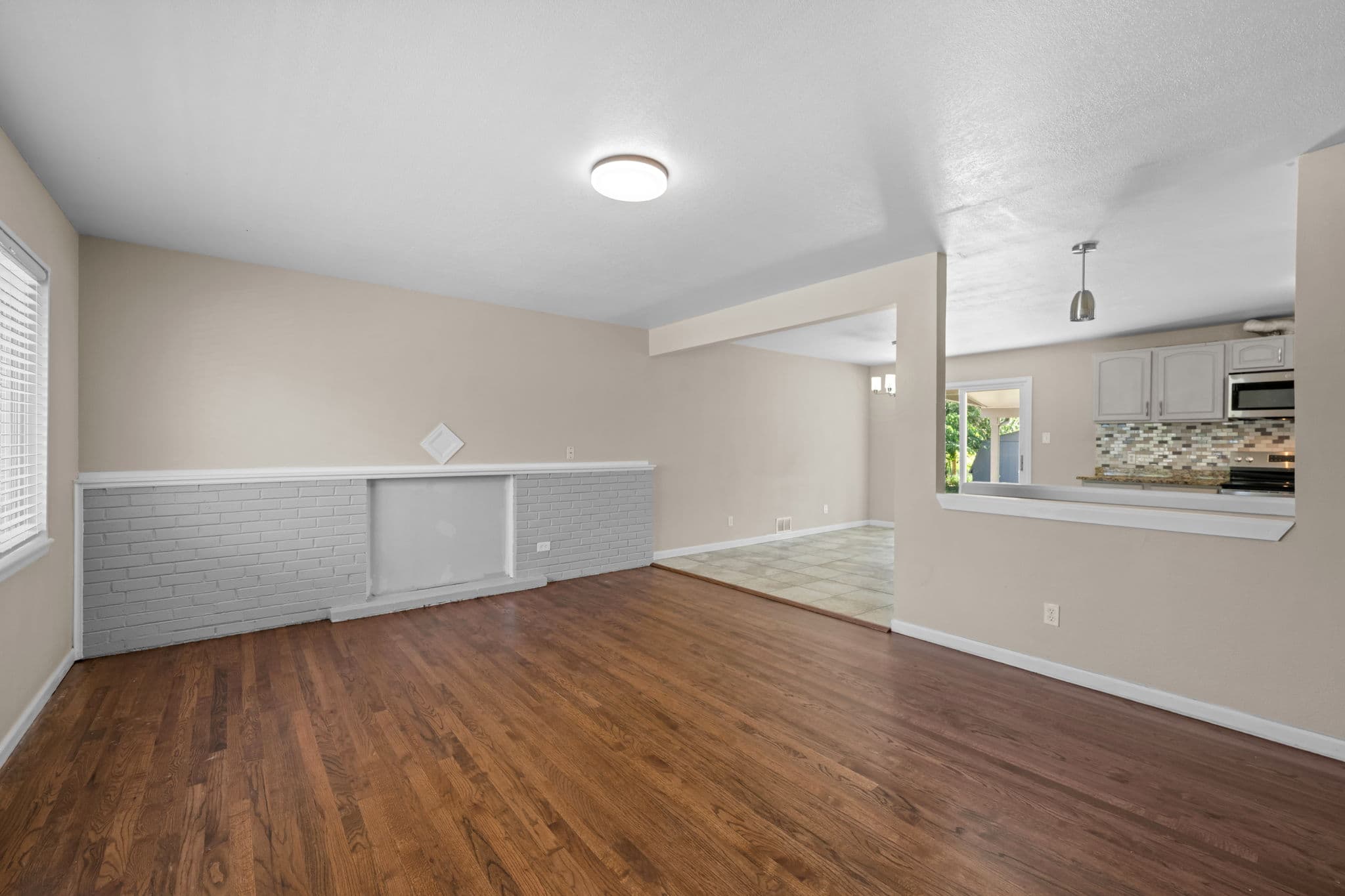 The living room, with hardwood floors, open to the kitchen